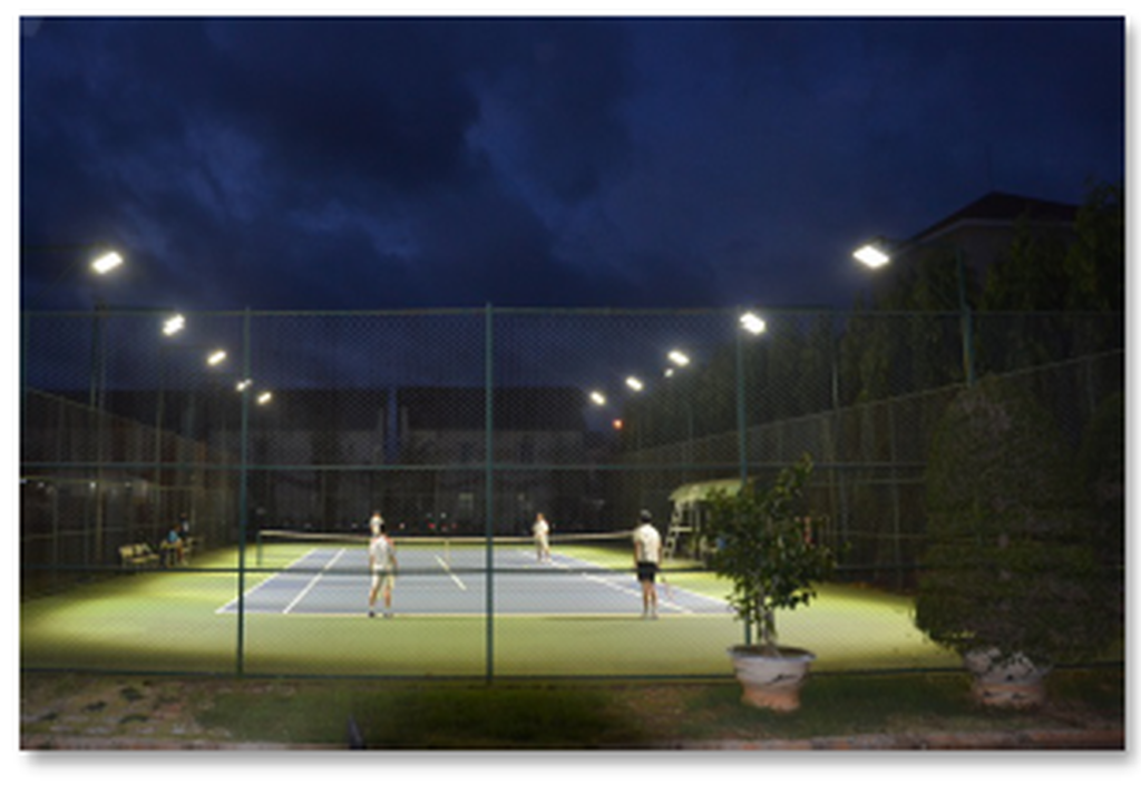 Outdoor tennis court lighting with pole-mounted LED sports lights for night play